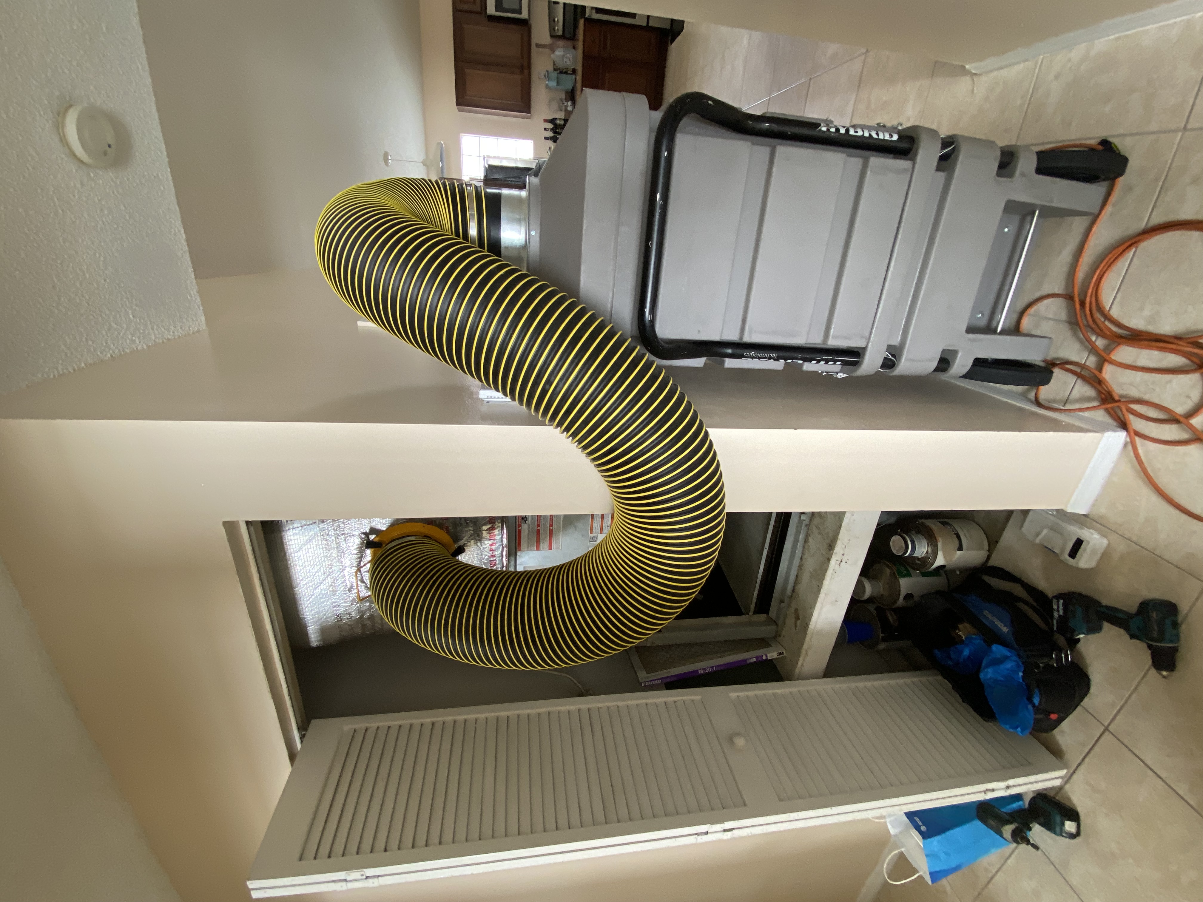 Negative air machine connected to HVAC system in modern apartment during duct cleaning