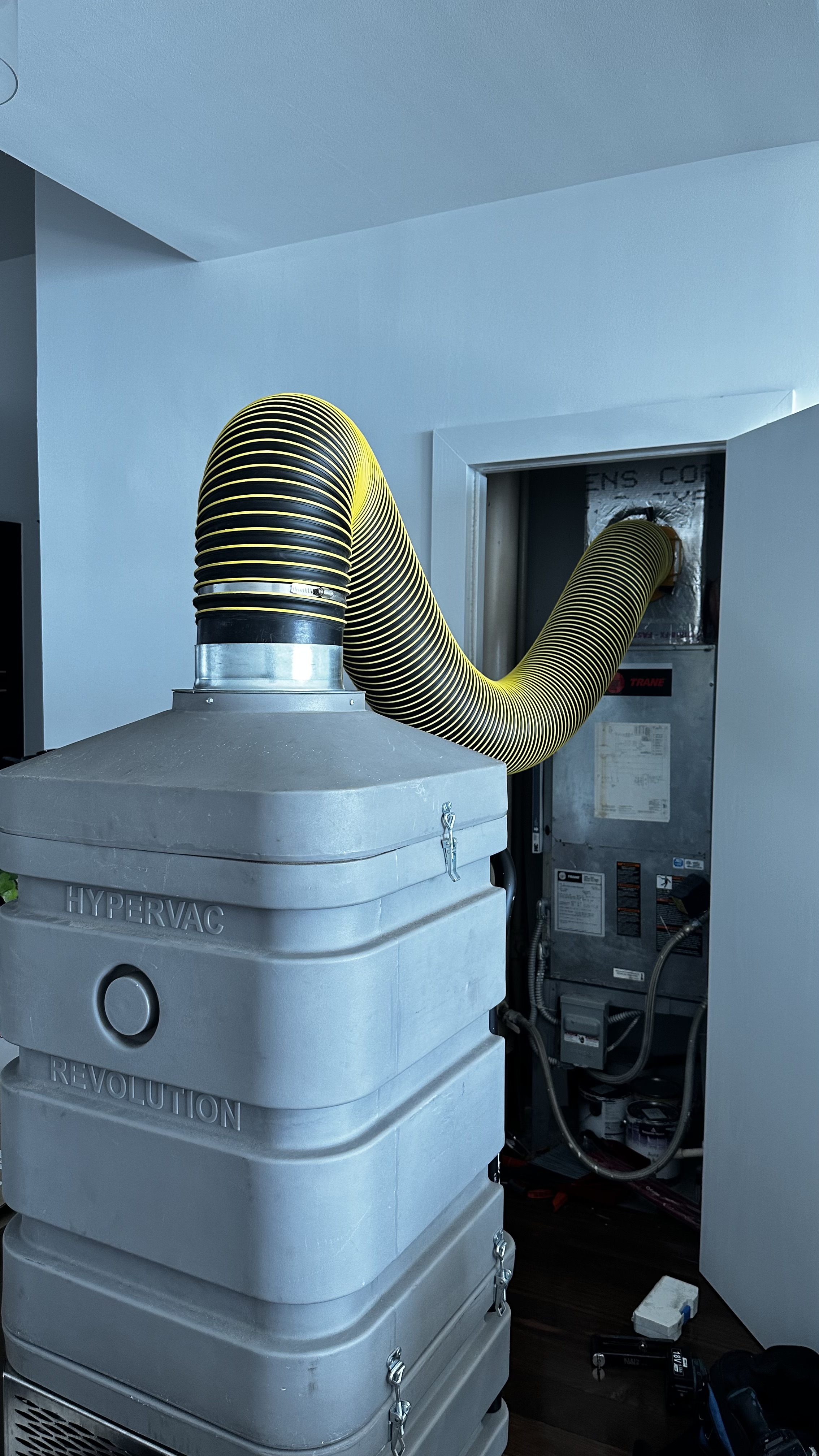 Negative air machine connected to HVAC system in modern apartment during duct cleaning